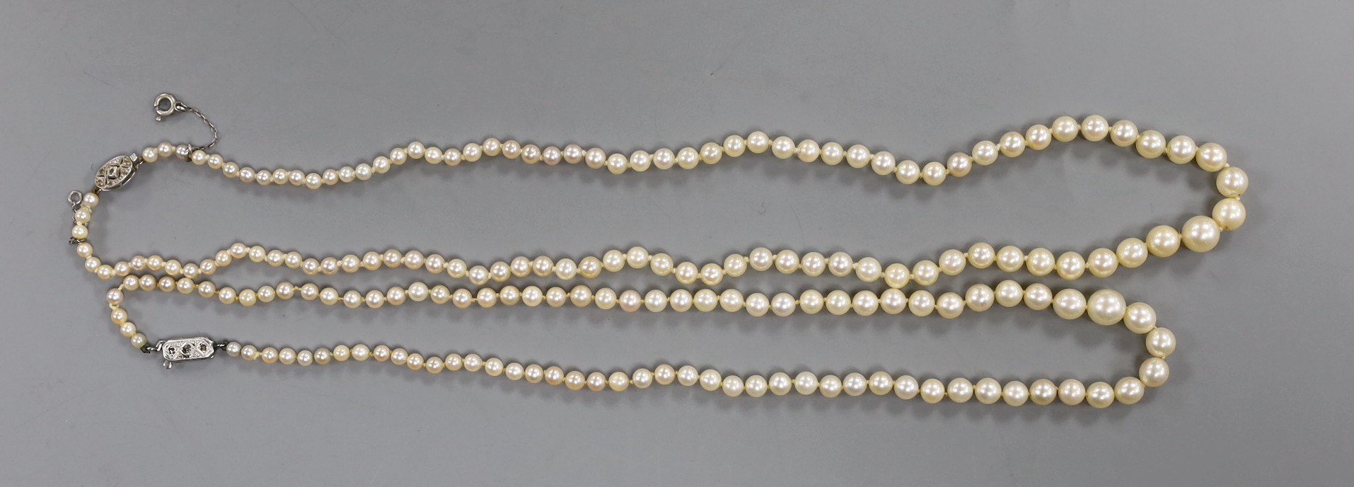 Two single strand graduated cultured pearl necklaces, both with diamond set clasps, one stamped 9ct and plat, longest 48cm.